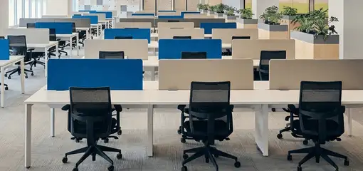 Modern open-plan office space featuring clean workstations, ergonomic chairs, and sanitized carpets provided by professional office cleaning services in Riverside, CA.