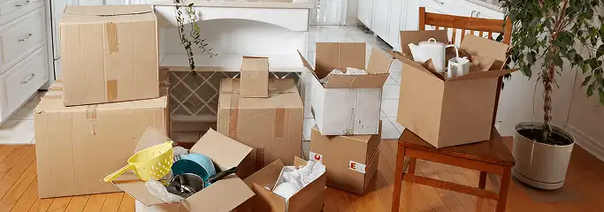 Packed moving boxes and household items in a kitchen before move-out or move-in cleaning, Riverside, CA.